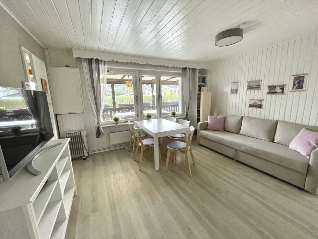 Wohnzimmer, Blick auf den weißen Esstisch und die hellbraune Couch