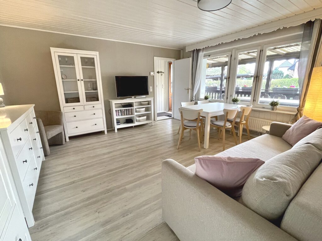 Wohnzimmer, Blick auf den Eingang, links davon Fernseher und Schrank